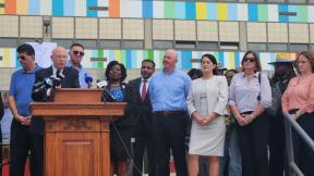 Arthur Steinberg speaks on the steps of South Philadelphia High School flanked by Democratic state legislators.